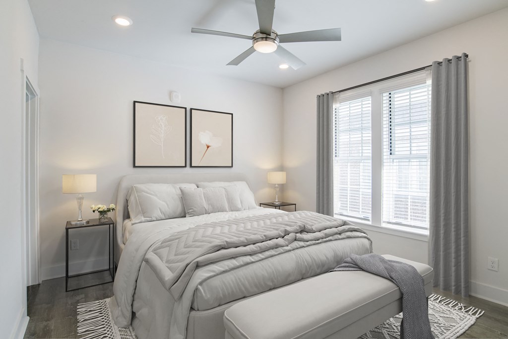 a white bedroom with a large bed and a ceiling fan