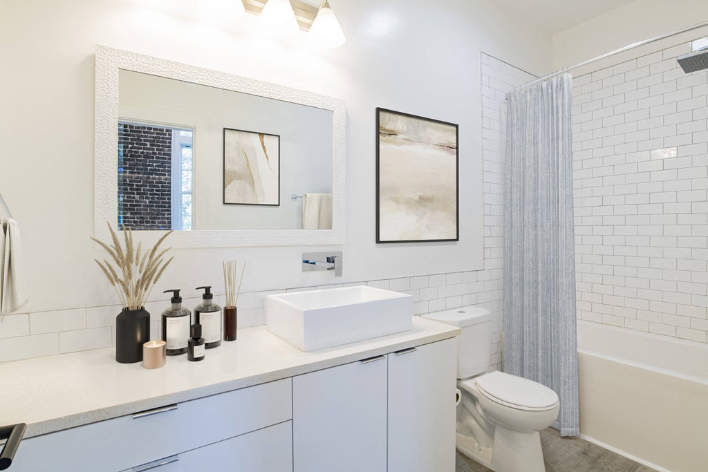 a white bathroom with a sink and a shower
