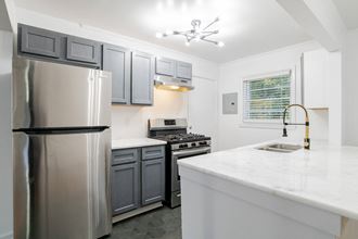a kitchen with white countertops and gray cabinets