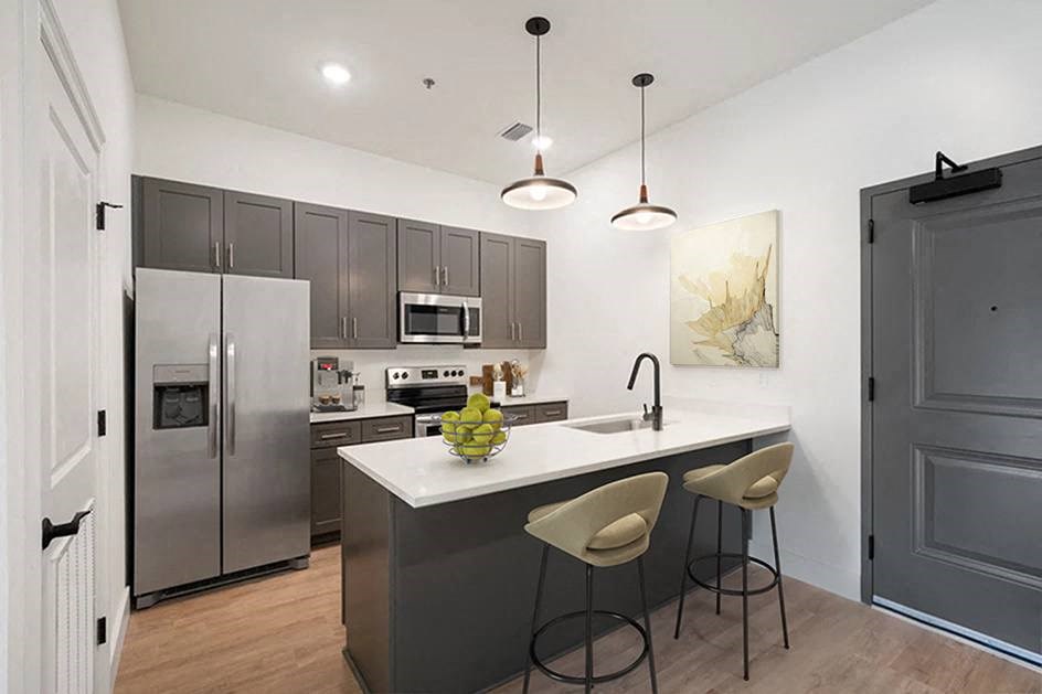 a kitchen with stainless steel appliances and an island with three stools