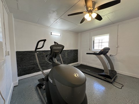 a gym with a exercise bike and a ceiling fan at Ann Street Lofts, Mobile