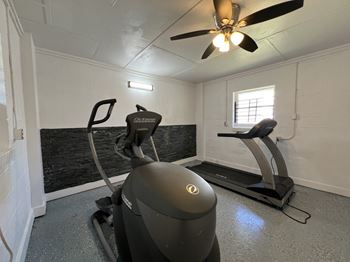 a gym with a exercise bike and a ceiling fan at Ann Street Lofts, Mobile, 36604