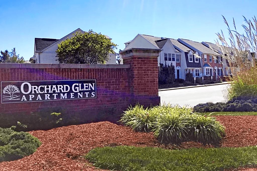 a brick wall with a sign that reads apartments
