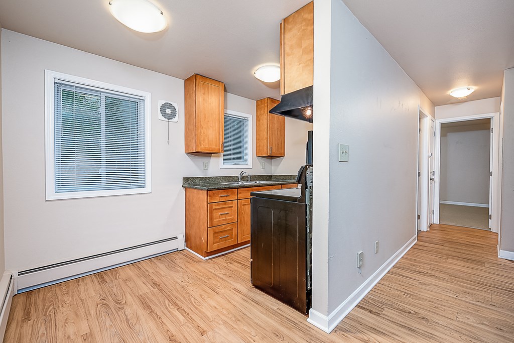 a kitchen with wooden cabinets and a black counter top