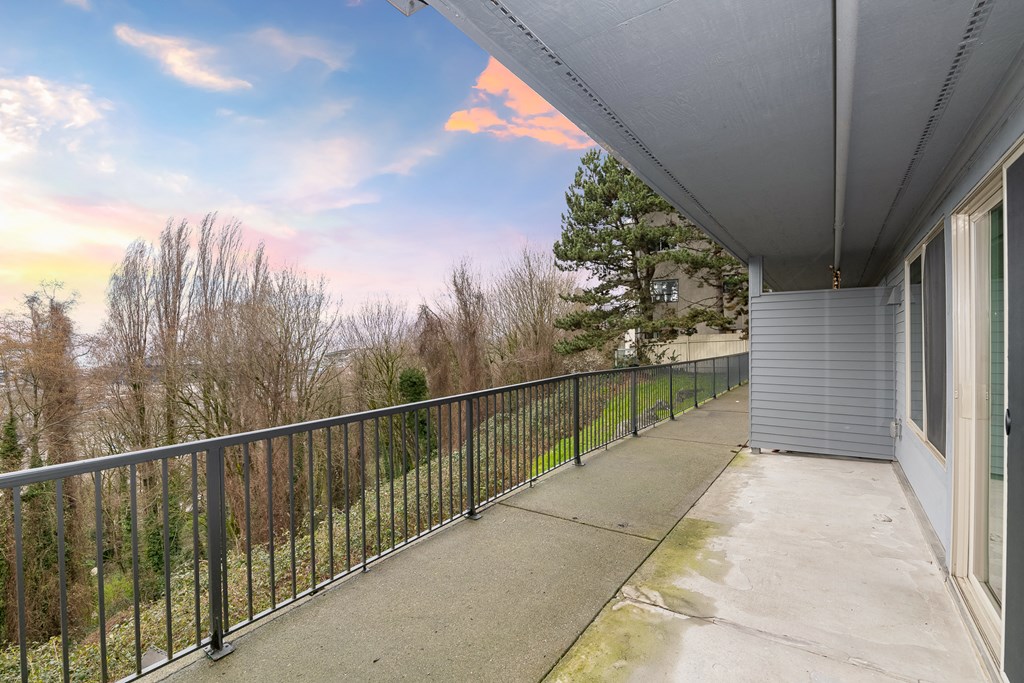 a balcony with a metal railing and a view of trees
