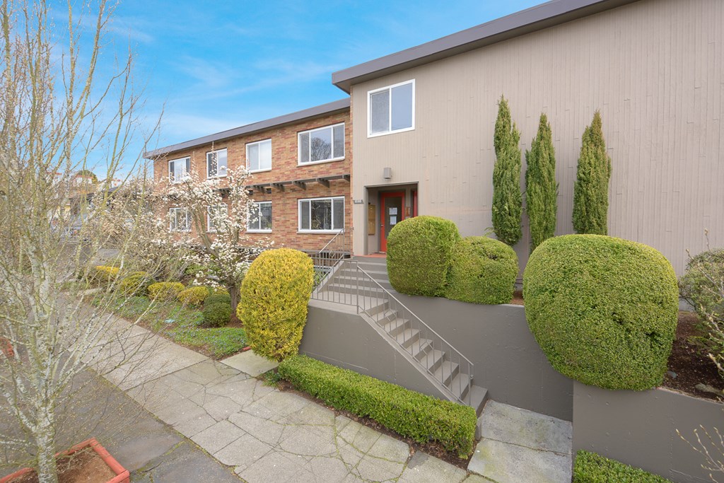 the front of a house with a garden and a staircase