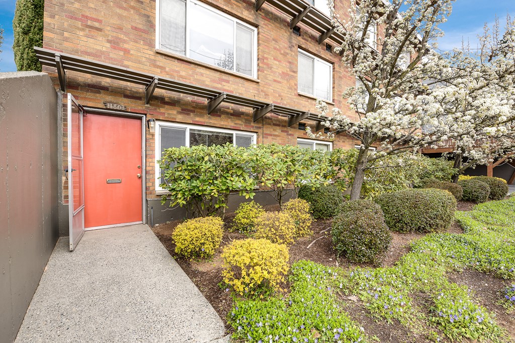the front of a brick house with a red door