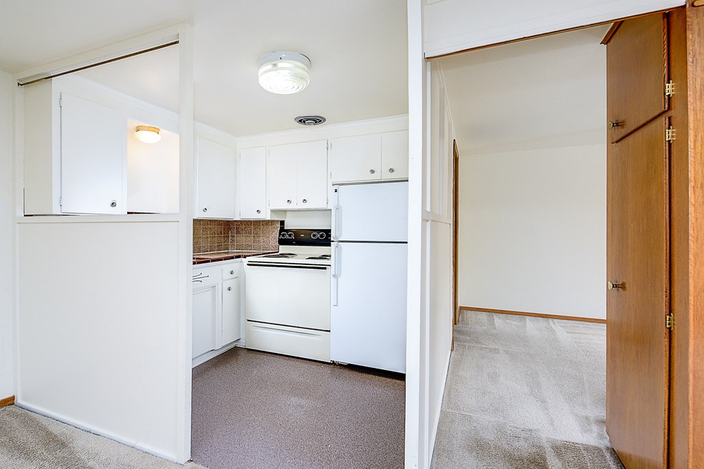 a renovated kitchen with white appliances and white cabinets