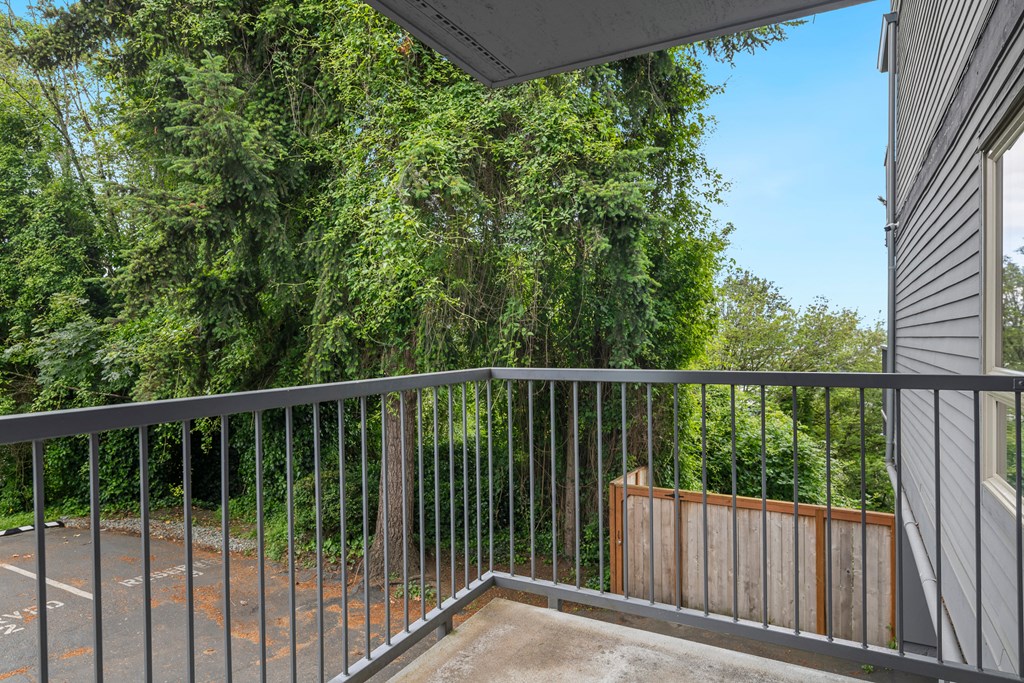a balcony with a fence and trees in the background