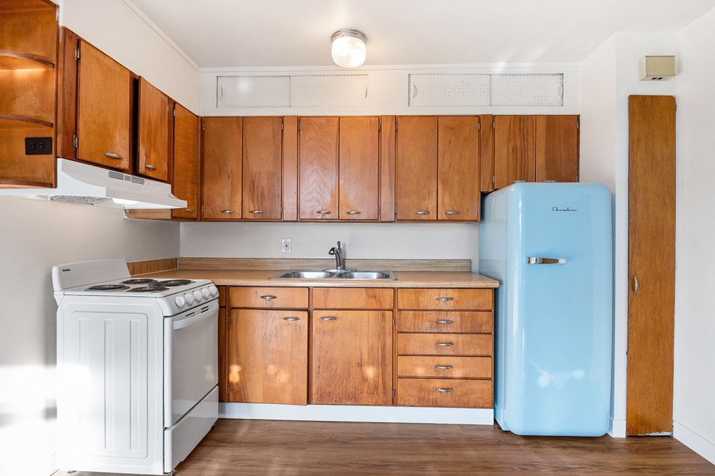 an empty kitchen with a stove refrigerator and sink