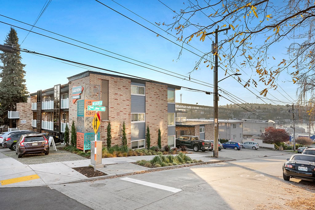 an apartment building on the corner of a street with cars