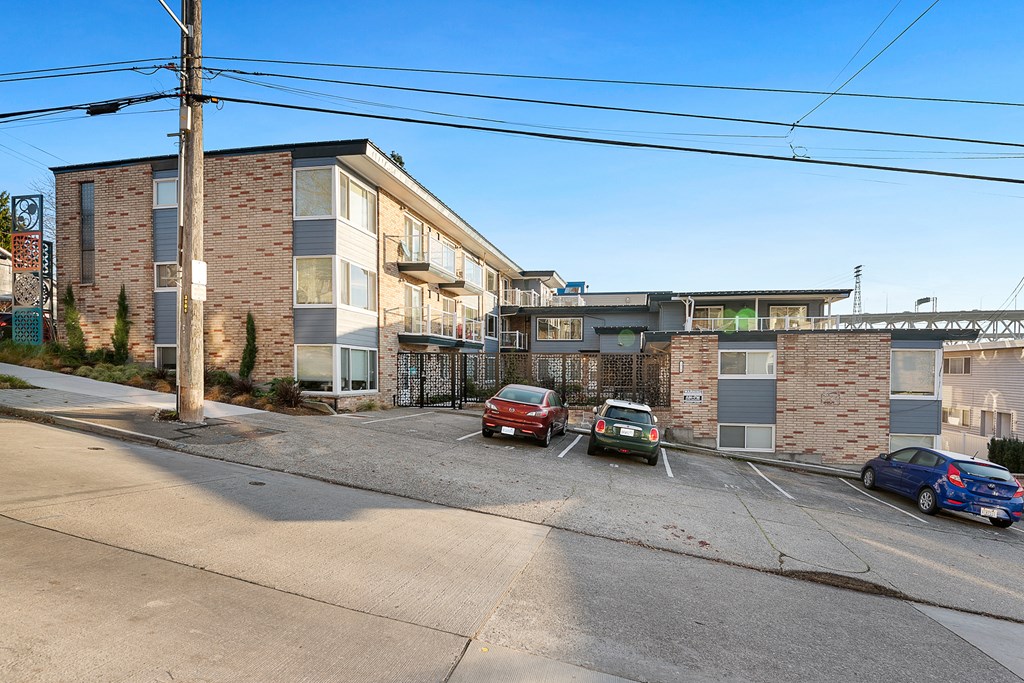 a parking lot with cars in front of an apartment building
