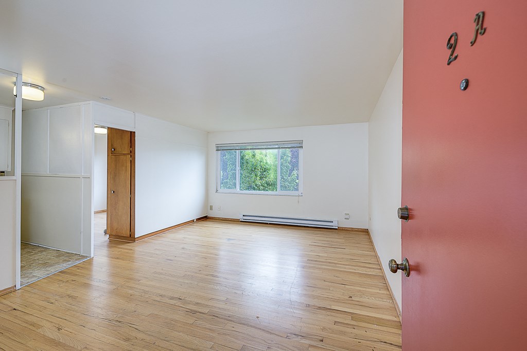 a living room with wood floors and a red door