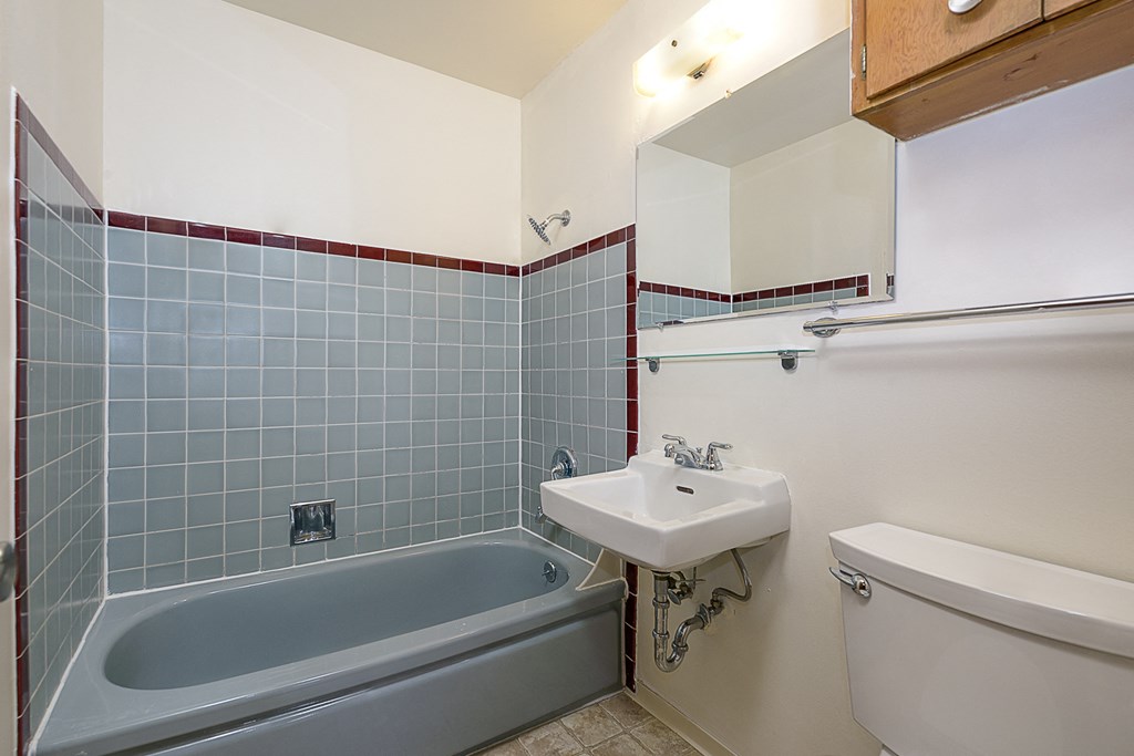 a bathroom with a sink toilet and bath tub and a mirror