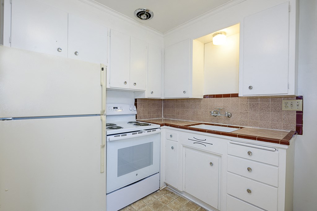 a kitchen with white appliances and white cabinets
