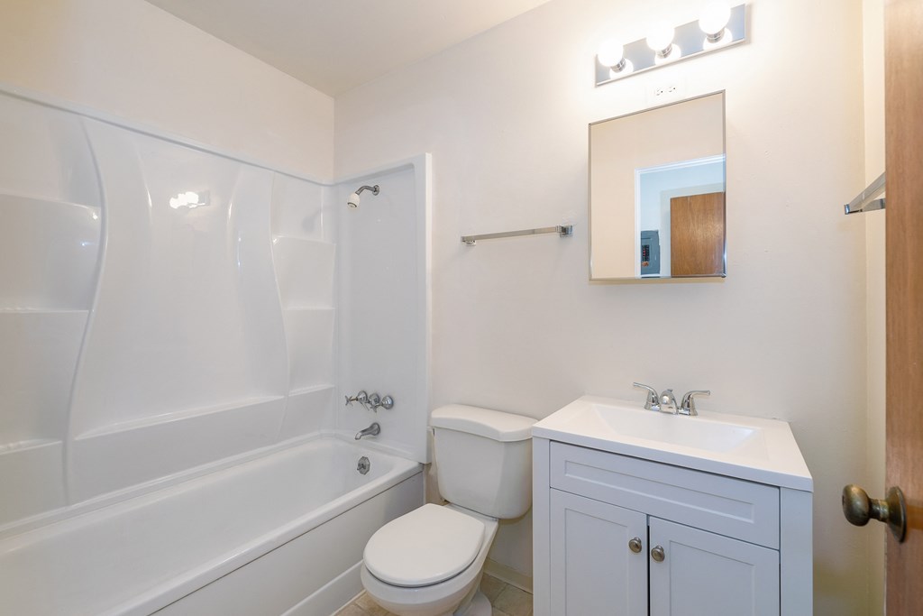 a bathroom with a tub sink and toilet