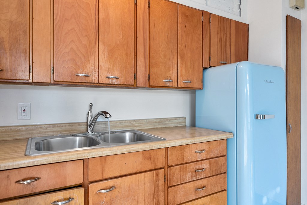 a kitchen with wooden cabinets and a blue refrigerator