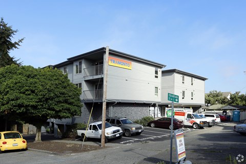 the front of a building with cars parked in a parking lot