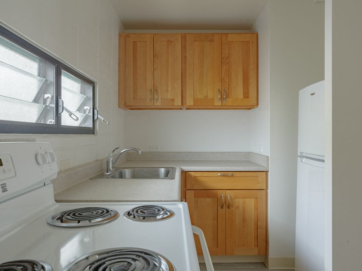 Kapiolani Village kitchen area with appliances and cabinets