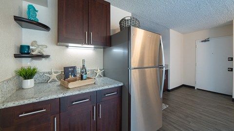 Waikiki Walina Apartments entry way and kitchen area with appliances, cabinets, and counters