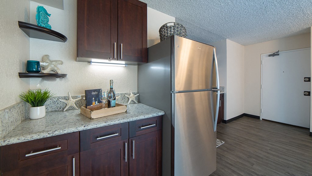 Waikiki Walina Apartments entry way and kitchen area with appliances, cabinets, and counters