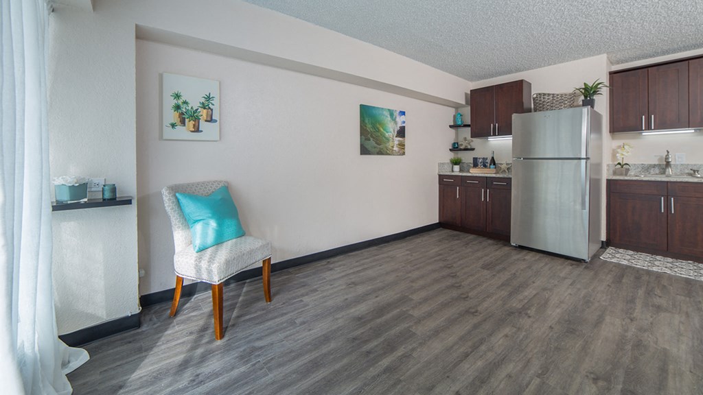 Waikiki Walina Apartments living area with decor and kitchen area with appliances, cabinets, and counters