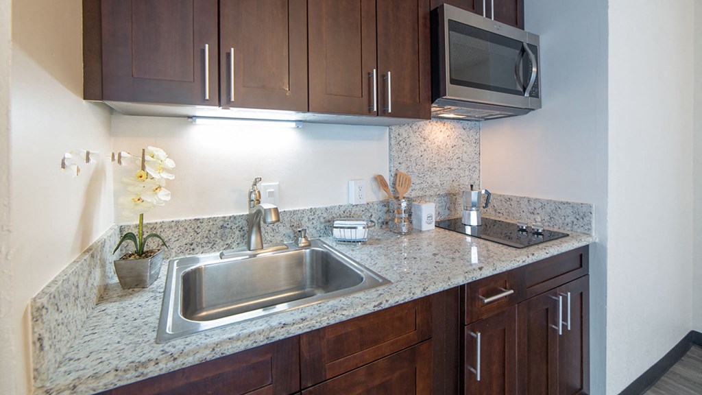 Waikiki Walina Apartments kitchen area with appliances, cabinets, and counters