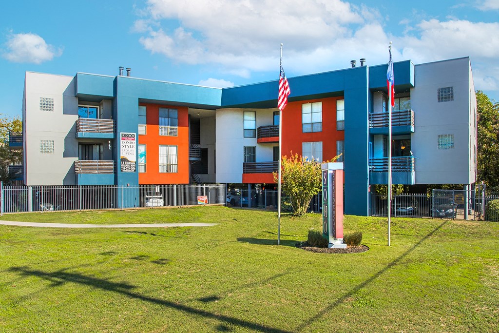 a blue and orange school building with two flags in front of it