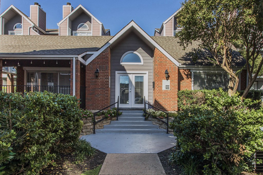 A brick building with a white door and a small porch.