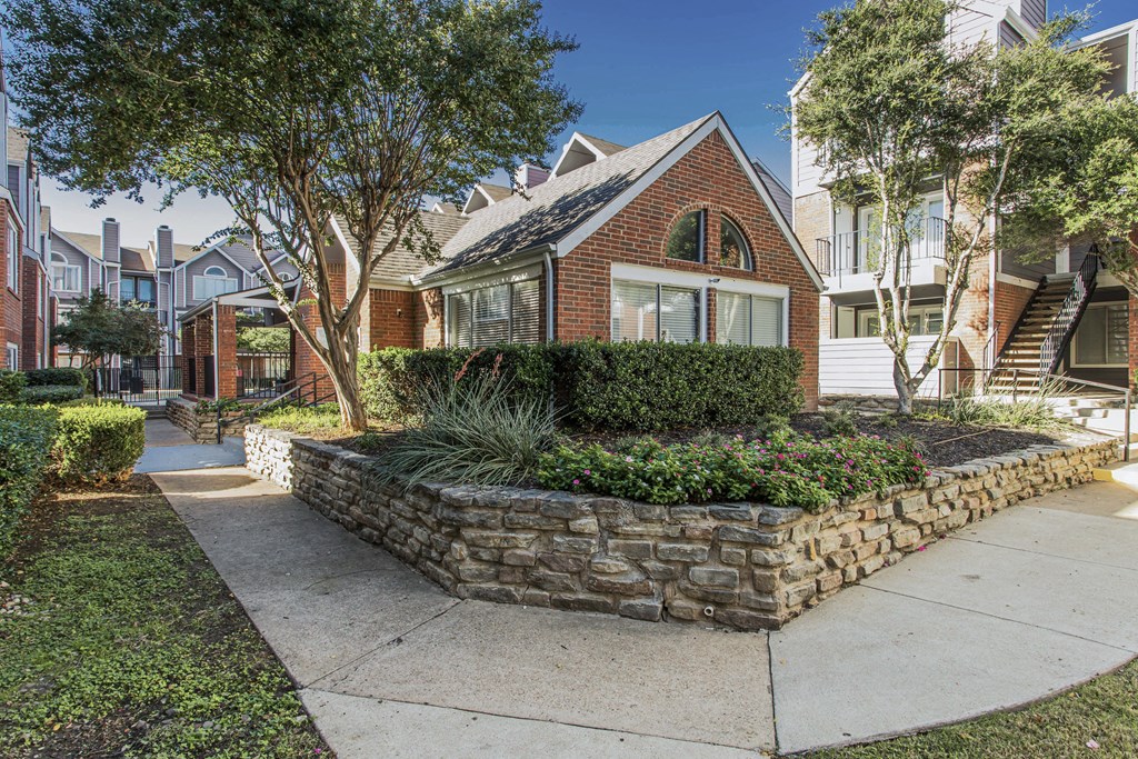 A house with a stone wall in front.