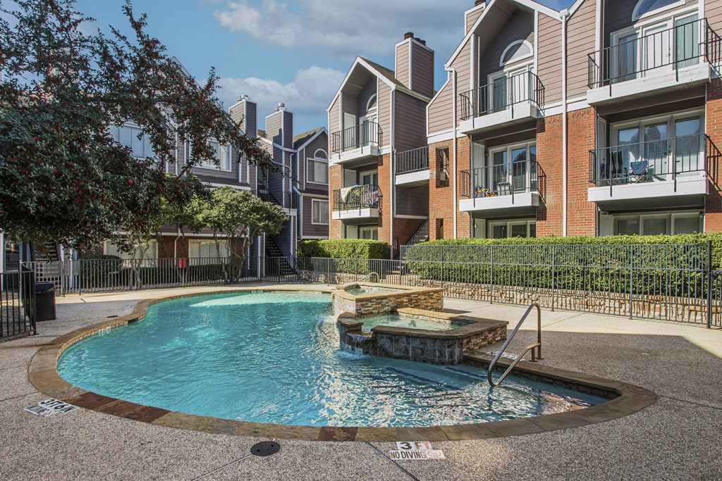 A swimming pool in front of apartment buildings.