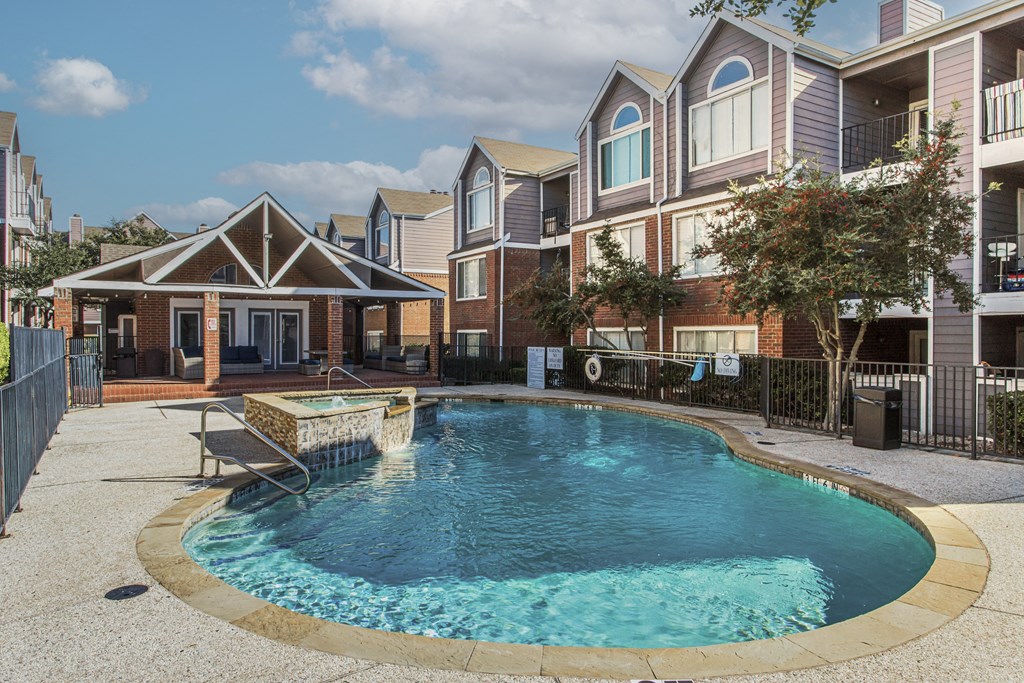 A swimming pool in a residential area surrounded by houses.