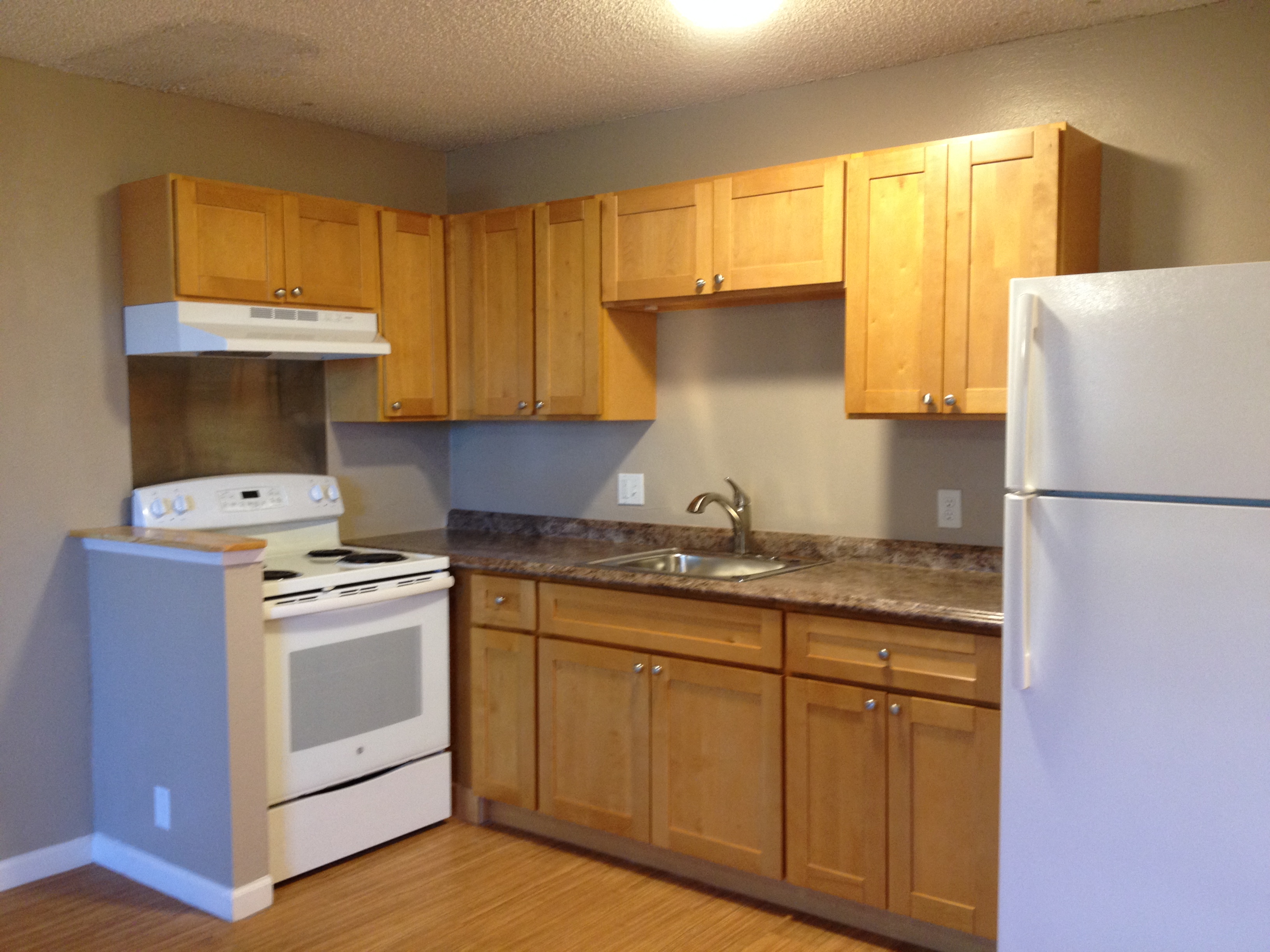 a kitchen with white appliances and wooden cabinets
