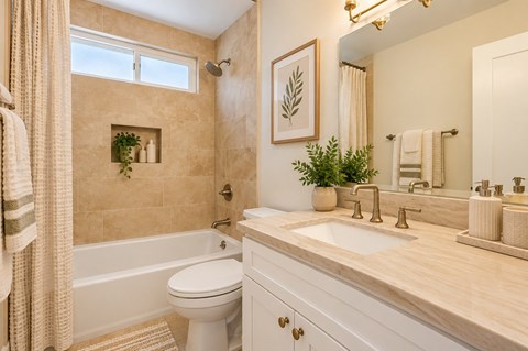 Staged Ocean View Townhomes bathroom with a toilet, sink, and tub.