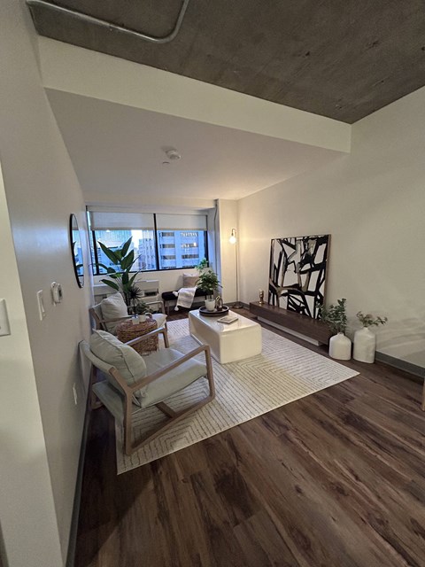 A living room with a wooden floor and a white wall.