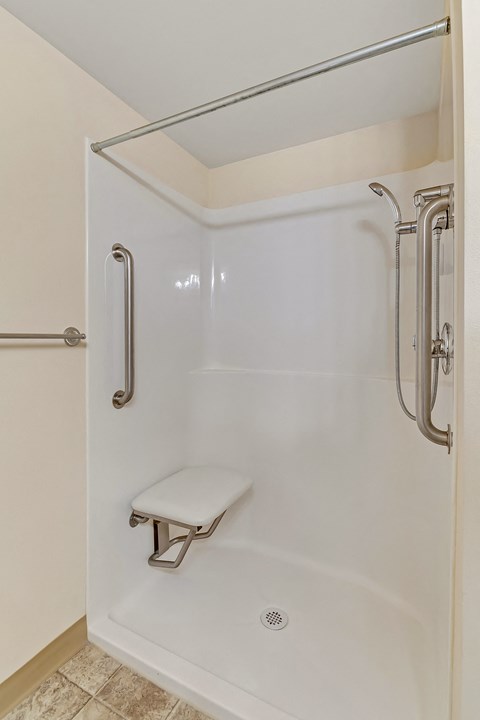 a white shower with a seat in a bathroom
