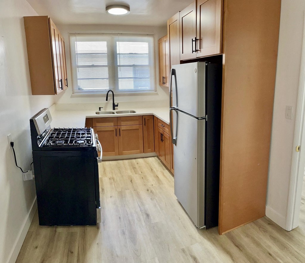 an empty kitchen with a stove and a refrigerator