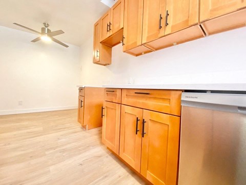 a kitchen with wooden cabinets and a ceiling fan