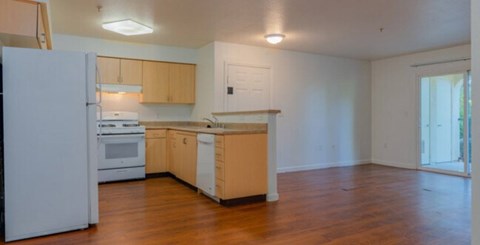 A kitchen with wooden floors and white appliances.