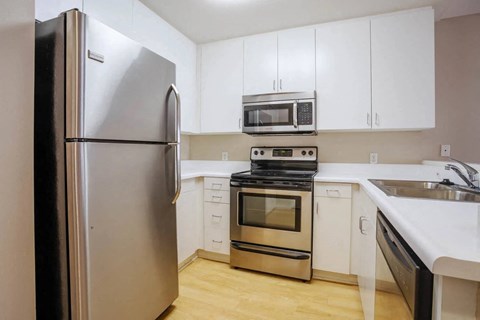 a kitchen with stainless steel appliances and white cabinets