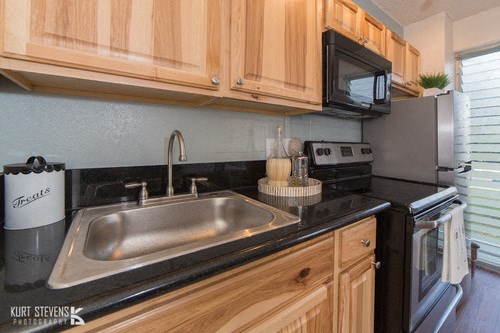 Kewalo Apartments kitchen area with appliances, counters, and cabinets