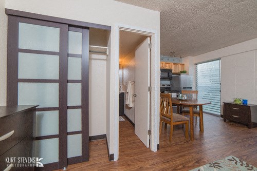 Kewalo Apartments dining and living area with decor, closet, and bathroom doorway