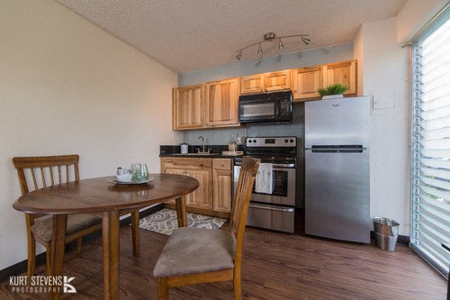 Kewalo Apartments dining area with decor and kitchen area with appliances, counters, and cabinets