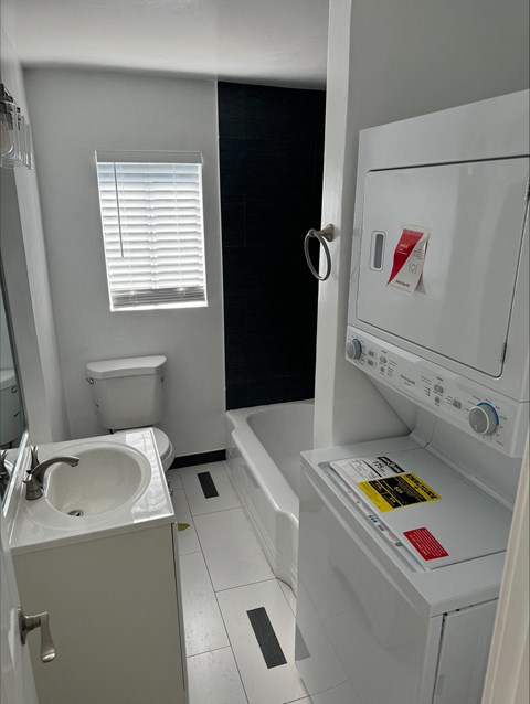 a small bathroom with a sink toilet and tub and a washing machine