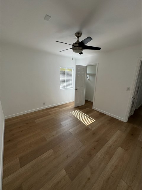 a living room with hardwood floors and a ceiling fan