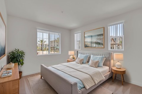 A bedroom with a large bed, a wooden nightstand, and a painting on the wall.