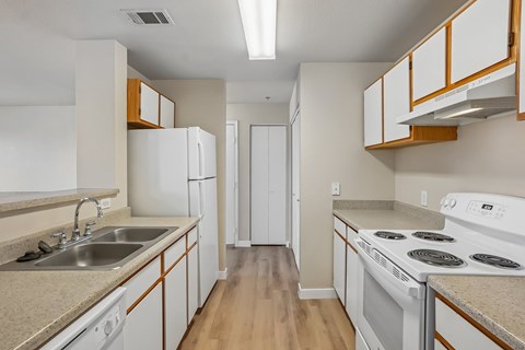 A kitchen with white cabinets and a stove top oven.