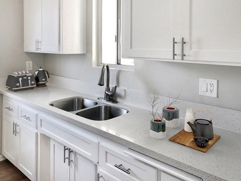 a kitchen with white cabinets and a sink