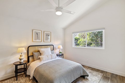 a bedroom with a bed and a ceiling fan