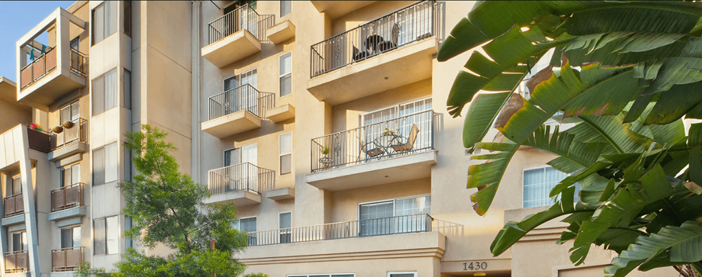 a view of an apartment building with balconies and trees